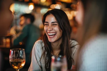 Fotobehang Carefree woman laughs while talking to her friends in pub © Kien