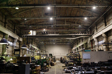 No people wide shot of old-fashioned industrial workshop interior equipped with various machines, copy space