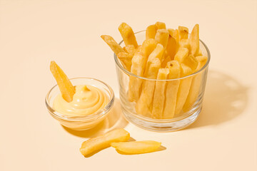 French fries with mayonnaise in glass on light background