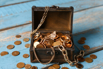 Old chest with treasures on blue wooden background