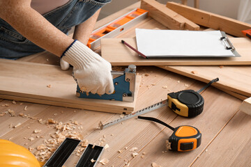 Female carpenter with construction stapler in workshop, closeup - obrazy, fototapety, plakaty