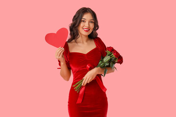 Beautiful young Asian woman with paper heart and bouquet of roses on pink background. Valentine's...