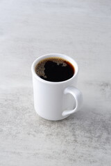 淹れたてのコーヒーが入った白いマグカップ
