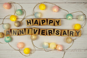 Happy Anniversary alphabet letters with LED cotton balls decoration on wooden background