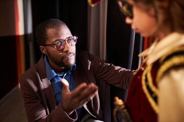 High angle portrait of caring African American drama teacher giving motivational pep talk to little...