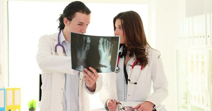 Two doctors performing a medical x-ray scan of feet and toes with Hallux Valgus deformity