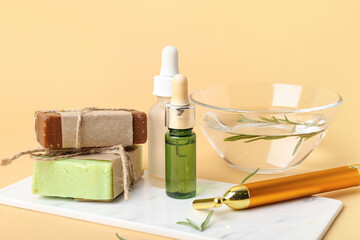 Composition with essential oil, soap bar and facial massage tool on color background