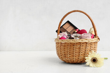 Fototapeta na wymiar Wicker basket with decorative cosmetics, Easter eggs and flowers on white background