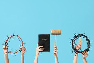 Female hands with crowns of thorns, Holy Bible and mallet on color background. Good Friday concept