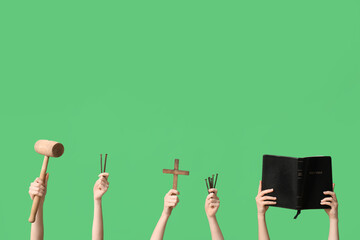 Female hands with Holy Bible, cross, mallet and nails on green background. Good Friday concept