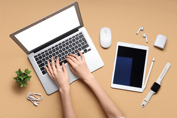 Female hands with modern devices on color background