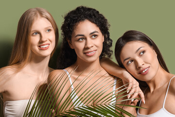 Beautiful young women with palm leaf on green background, closeup