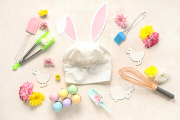 Cooking utensils with Easter eggs, flowers and bunny ears on white background