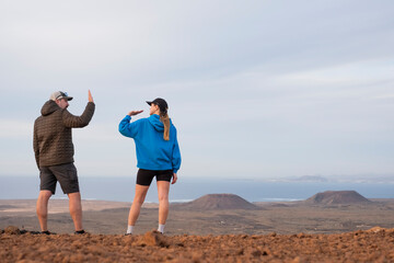 Pareja contenta chocando las cinco y haciendo actividades al aire libre, caminando cerca del...