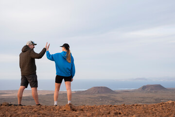 Pareja contenta haciendo actividades al aire libre, caminando cerca del volcán Fuerteventura, Islas Canarias - obrazy, fototapety, plakaty