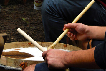 Rustic bass drum being played with drumsticks