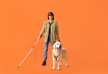 Blind woman with guide dog on orange background