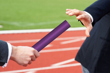 Businessman passing purple baton to partner concept succession support teamwork 