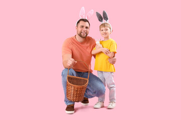 Little boy and his father in bunny ears with basket on pink background. Easter celebration