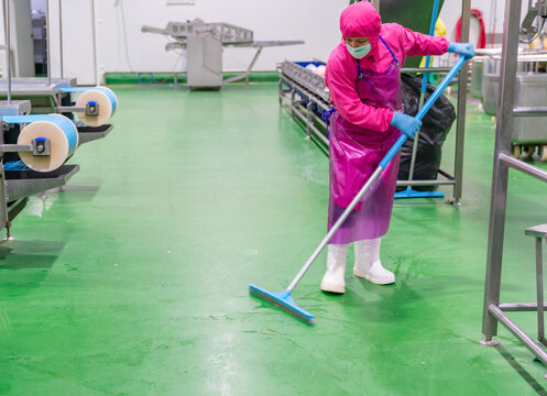 The cleaning staff use mops to clean the factory floor.