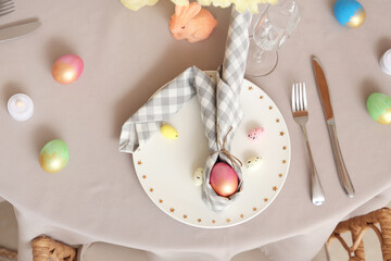 Beautiful table setting with cutlery, napkins and painted Easter eggs