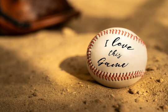 Baseball ball and glove on the sand. Close up
