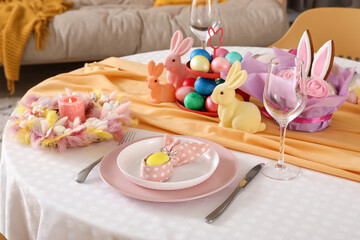 Festive table serving with painted eggs and bunnies for Easter celebration