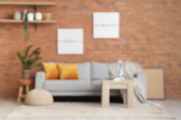 Loft style living room with comfortable sofa and table, blurred view