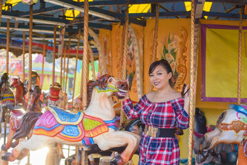 Portrait of smiling woman with positive attitude on a carousel stopped at a fair in Mexico.