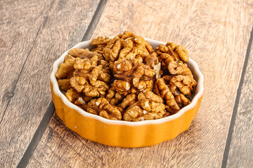 Cracked unshelled walnut in the bowl
