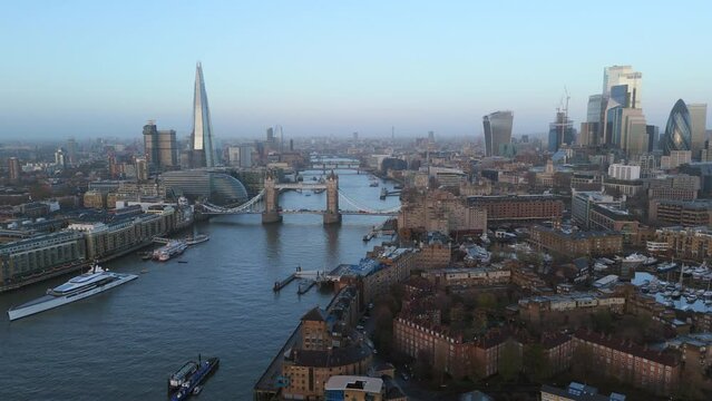 Early morning light washes over the London skyline with a view of Tower Bridge, The Shard, and the Thames River, signaling the start of a new day. Slow Motion, 4K RAW. 