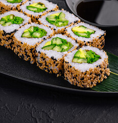 vegetarian sushi rolls on black plate