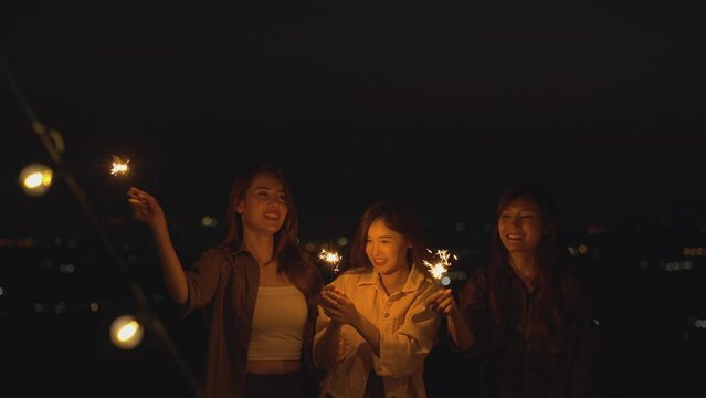 Group of Asian young women having fun and enjoying sparklers at night. Females, Lifestyle Relaxation, Vacations Camping trip, Travel