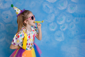 Funny kid clown playing against a bright wall. 1 April Fool's day concept, birthday concept