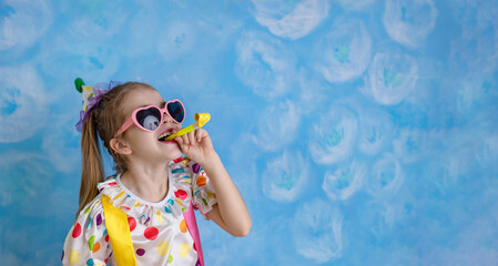 Funny kid clown playing against a bright wall. 1 April Fool's day concept, birthday concept - obrazy, fototapety, plakaty