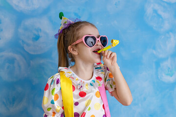 Funny kid clown playing against a bright wall. 1 April Fool's day concept, birthday concept