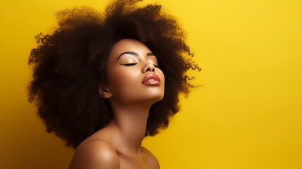 Afro-haired young brunette lady with closed eyes and creative yellow make-up, lips, and eyeshadows stand on a colorful background and gives a kiss to the camera.