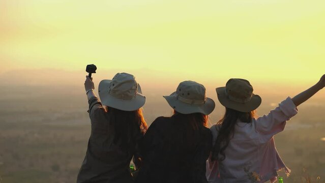 Group of Asian young women having fun and enjoying a summer vacation vlogging from the mountain in nature during sunset. Females Lifestyle, blogger travel