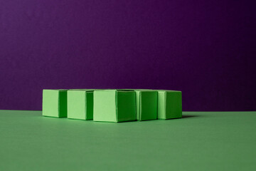 Arranged Green Cubes Casting Shadows on Green Teal Surface - Abstract Design Representing Eco-Friendly Development