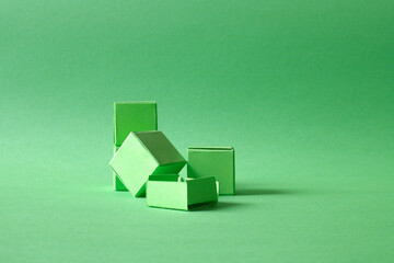 Arranged Green Cubes Casting Shadows on Green Teal Surface - Abstract Design Representing Eco-Friendly Development