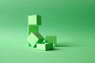 Arranged Green Cubes Casting Shadows on Green Teal Surface - Abstract Design Representing Eco-Friendly Development