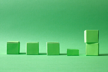 Arranged Green Cubes Casting Shadows on Green Teal Surface - Abstract Design Representing Eco-Friendly Development