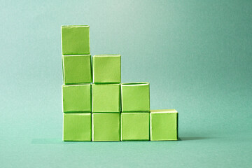 Ascending Stack of Green Cubes on a Soft Teal Background - Geometric Art