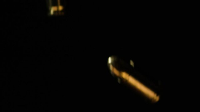 9mm Parabellum Firearm Cartridges And .300 AAC Blackout Falling Against Black Background. - close up shot