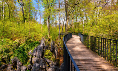 Panorama with pedestrian bridge crossing a small canyon in the “Felsenmeer“ in Hemer Sauerland...