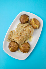 Tasty pieces of baked potatoes and salt and oil on plate