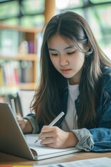 A girl is focused on writing in a notebook at a table. Suitable for educational and creative concepts