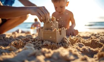 Foto op Canvas A child's hand building a sandcastle. Family beach vacation © piai