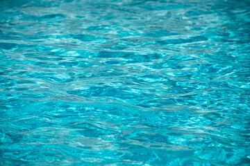 Water background, ripple waves. Blue swiming pool pattern. Sea surface. Water in swimming pool with sun reflection. Banner with copy space.