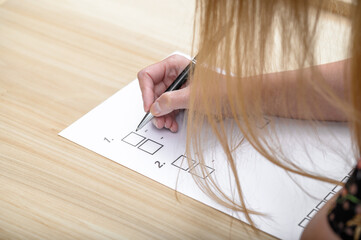 Kobieta pisze egzamin, rozwiązuje test i zaznacza prawidłowe odpowiedzi  - obrazy, fototapety, plakaty